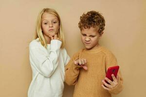 süß stilvoll Kinder Umarmung Unterhaltung Selfie posieren Freundschaft Beige Hintergrund foto