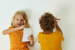 süß Vorschule Kinder Emotionen Zeichnung zusammen Notizblock und Bleistifte Licht Hintergrund unverändert foto