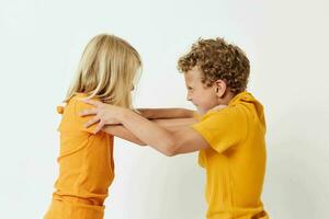 Porträt von süß Kinder im Gelb T-Shirts Stehen Seite durch Seite Kindheit Emotionen unverändert foto