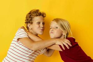 zwei froh Kinder Stehen Seite durch Seite posieren Kindheit Emotionen auf farbig Hintergrund foto