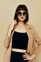 schön Frau im ein Beige Jacke elegant Stil Sonnenbrille Lebensstil unverändert foto