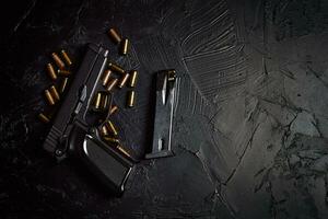 Pistole mit Patronen auf schwarzem Betontisch foto
