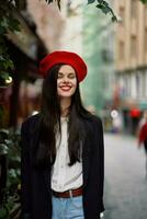Frau Lächeln Mode Modell- Spaziergänge auf das Straße im das Stadt Center unter das Menge im ein Jacke und rot Baskenmütze und Jeans, filmisch Französisch Mode Stil Kleidung, Reise zu Istanbul Frühling foto