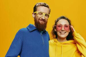 Mann und Frau Paar lächelnd fröhlich und krumm mit Gläser, auf Gelb Hintergrund, Symbole Zeichen und Hand Gesten, Familie schießen, Jungvermählten. foto