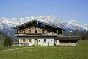 österreichisch traditionell Tiroler Familie Haus im das Schnee. alpin Zuhause mit Winter schneebedeckt Berge Hintergrund. foto