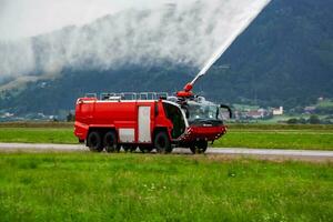 Feuer Kampf mit Wasser sprühen. Feuer LKW und Feuer Motor mit Feuer Männer. Notfall und Feuersbrunst. Feuer Katastrophe und Krise. foto