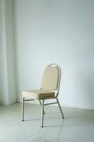 comfotable Stuhl im leeren Weiß Zimmer. leeren Stuhl beim das Zimmer Ecke. Einsamkeit Konzept foto