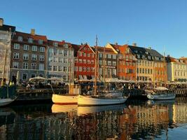 nyhavn beim Sonnenuntergang mit bunt Häuser und Boote foto