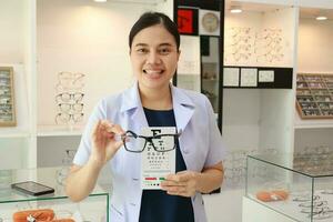 weiblich Augenarzt halten Brille Innerhalb Klinik, Auge Arzt halten Brille im Brille Geschäft, Augenarzt halten Brille im Brille Klinik foto