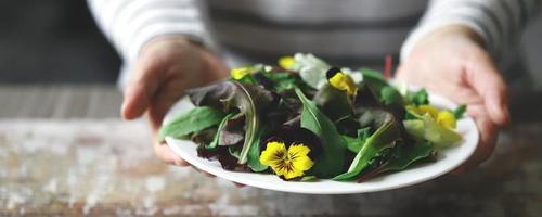 gesunder Salat mit Blumen auf einem Teller foto