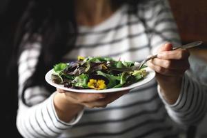gesunder Salat mit Blumen auf einem Teller foto