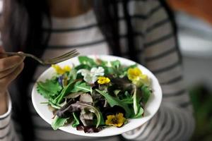 gesunder Salat mit Blumen auf einem Teller foto