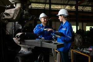 beide von mechanisch Ingenieure sind Überprüfung das Arbeiten Bedingung von ein alt Maschine Das hat gewesen benutzt zum etwas Zeit. im ein Fabrik wo natürlich Licht scheint auf zu das Arbeitsplatz foto