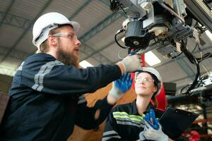 elektrisch Ingenieur mit das Mission von Installation ein Roboter Arm elektrisch System foto