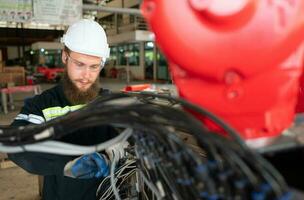 elektrisch Ingenieur mit das Mission von Installation ein Roboter Arm elektrisch System foto