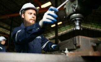 Porträt von mechanisch Ingenieure sind Überprüfung das Arbeiten Bedingung von ein alt Maschine Das hat gewesen benutzt zum etwas Zeit. im ein Fabrik wo natürlich Licht scheint auf zu das Arbeitsplatz foto