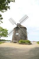 alte hölzerne Windmühle am Meer im Sommer foto