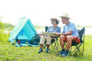 zwei asiatisch Alten Paare nehmen ein Natur Tour. Camping und genießen das schön natürlich Landschaft. das Konzept von natürlich Tourismus im Pensionierung Alter. foto