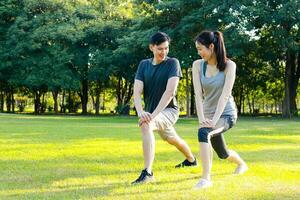 asiatisch männlich und weiblich Paar Übung im das draussen Park im das Morgen. Sie sind gesund, lächelnd und glücklich. Fitness Konzept, Gesundheit Pflege foto