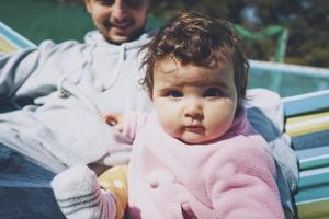 kleines Baby, das einen sonnigen Tag in den Ferien mit Papa genießt foto