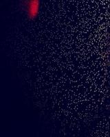 ein erstaunliches Makrobild von Wassertropfen mit schwarzem Hintergrund und einem roten Leuchten von einem hohen Licht foto