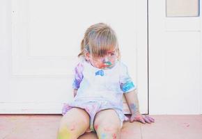 kleines Mädchen schmutzig von Farbe foto