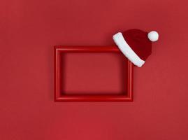 Rahmen und Weihnachtsmütze auf rotem Grund. foto