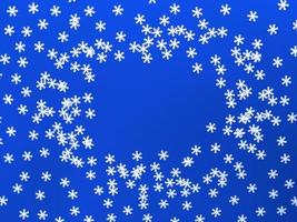 verstreute weiße Schneeflocken auf blauem Hintergrund. einfache flache Lage mit Kopienraum. Stock Foto. foto