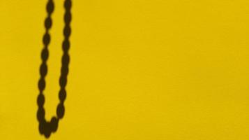 Japa Perlen Schatten auf gelbem Pastellpapier. abstrakter Hintergrund. Stock Foto.