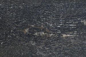 Textur der schwarzen Holzoberfläche, mit Rissen. Hintergrundbild foto