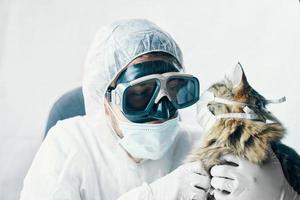 Mann im Anzug und Katze in einer medizinischen Maske foto