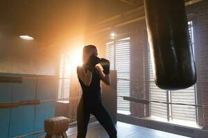 Frauen selbst Verteidigung Mädchen Leistung. stark Frau Kämpfer Ausbildung Schläge auf Boxen Ring. gesund stark Mädchen Stanzen Boxen Tasche. Ausbildung Tag im Boxen Fitnessstudio. Stärke passen Körper trainieren Ausbildung. foto