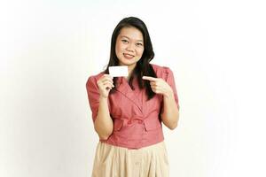 hält und zeigt leere Kreditkarte der schönen asiatischen Frau isoliert auf weißem Hintergrund foto