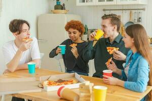 Zuhause Party freunde Ausgaben Zeit zusammen haben Spaß Lachen kommunizieren beim heim. glücklich vielfältig Gruppe Essen Pizza Trinken Bier oder Limonade. gemischt Rennen jung Freunde Beste freunde genießen Wochenende. foto