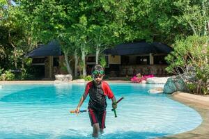 asiatisch wenig Mädchen im Badeanzug spielen mit Spielzeuge beim Schwimmen Schwimmbad glücklich und haben Spaß. foto