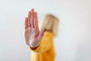 Frau angehoben ihr Hand zum abbringen, Kampagne halt Gewalt gegen Frauen. blond Frau angehoben ihr Hand zum abbringen mit Kopieren Raum foto
