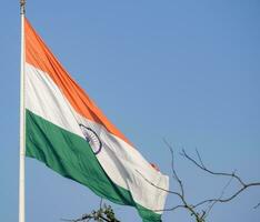 Indien-Flagge, die hoch am Connaught-Platz mit Stolz auf den blauen Himmel fliegt, Indien-Flagge flattert, indische Flagge am Unabhängigkeitstag und Tag der Republik Indien, Schuss nach oben geneigt, indische Flagge schwenkend, Har Ghar Tiranga foto