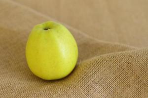 grüne rohe Apfelfrucht auf Sackleinenhintergrund foto