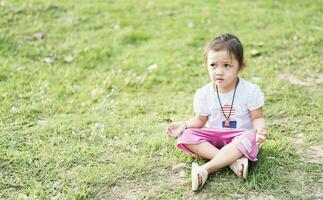 wenig asiatisch Mädchen üben Achtsamkeit Meditation draussen im ein Park. foto