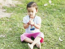 wenig asiatisch Mädchen üben Achtsamkeit Meditation draussen im ein Park. foto