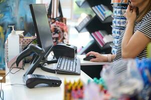 Frau Verkäufer im Büro liefern Geschäft, Gespräche auf Handy, Mobiltelefon Telefon, funktioniert auf pc Computer, Aufträge Fan-Shop foto