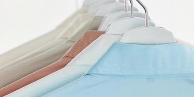 Herrenhemden, Kleider auf Kleiderbügeln auf weißem Hintergrund foto