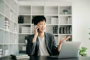 Porträt eines jungen Mannes, der an seinem Schreibtisch im Büro sitzt foto