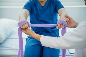 Physiotherapeut Portion geduldig während Dehnen seine Bein im Bett im Klinik foto