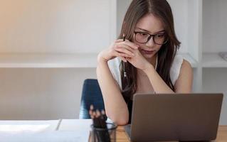 Porträt einer attraktiven asiatischen Geschäftsfrau, die mit einem Laptop für eine Online-Gruppenkonferenz arbeitet foto