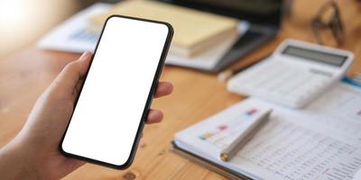 Modellbild einer Person, die ein Handy mit einem leeren weißen Bildschirm für Text hält foto