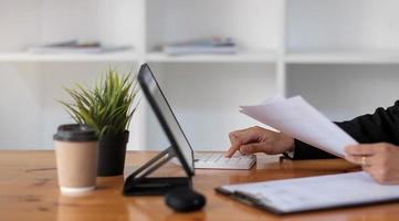 Hände der Geschäftsfrau mit Taschenrechner im Büro foto