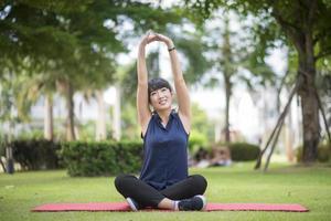 schöne Yoga-Frau auf grünem Park foto