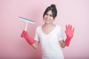 schöne asiatische Hausfrau, die auf rosa Hintergrund lächelt foto