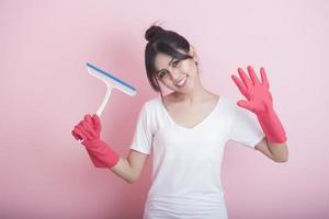 schöne asiatische Hausfrau, die auf rosa Hintergrund lächelt foto